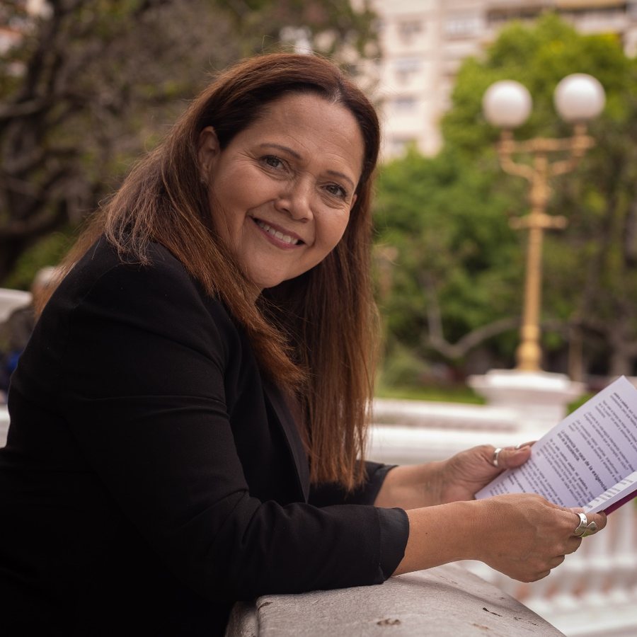 Liliana Bermúdez sonriendo con un libro en la mano